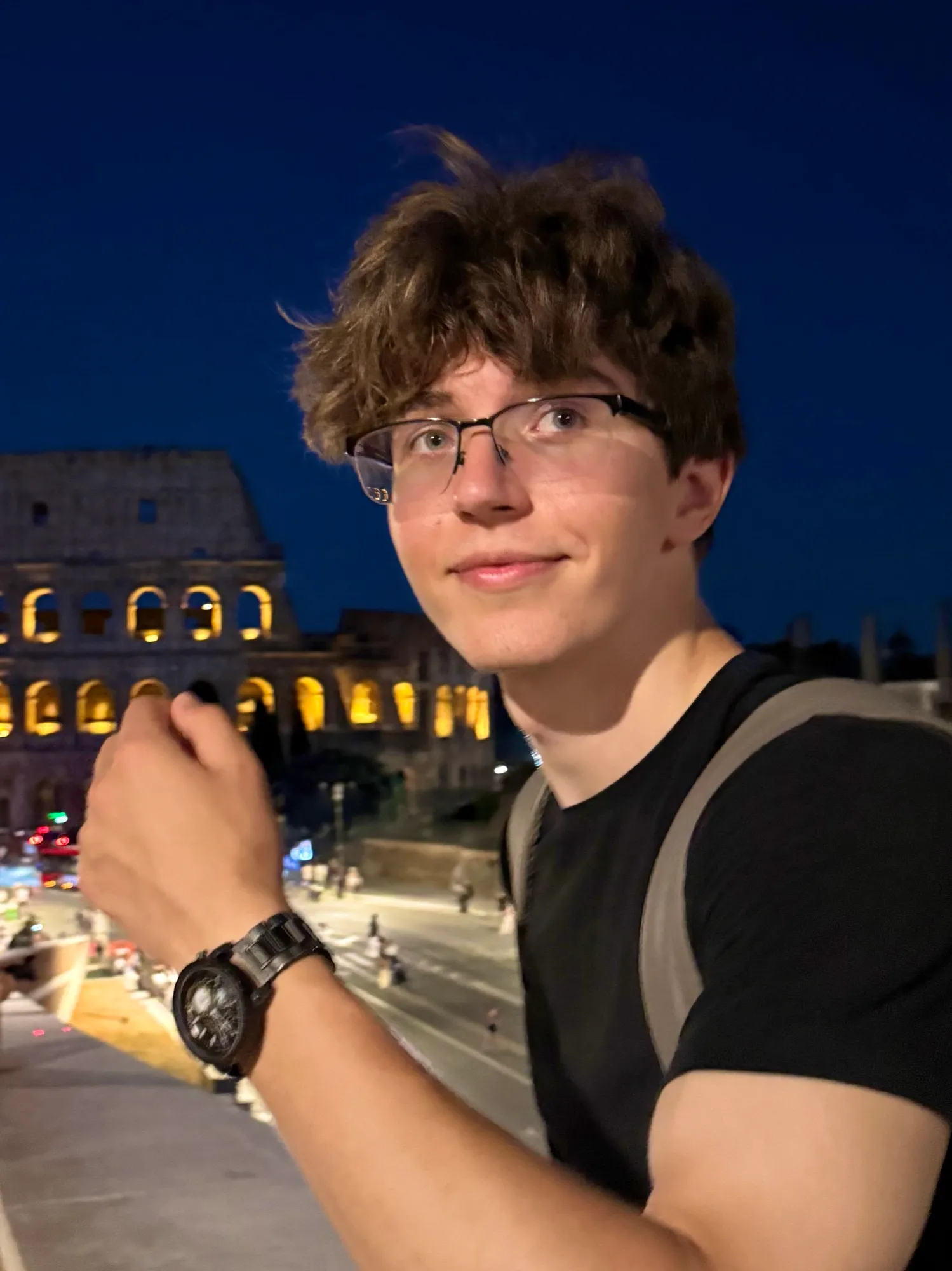 Vlad at night in Rome, with the Colosseum lit up behind him